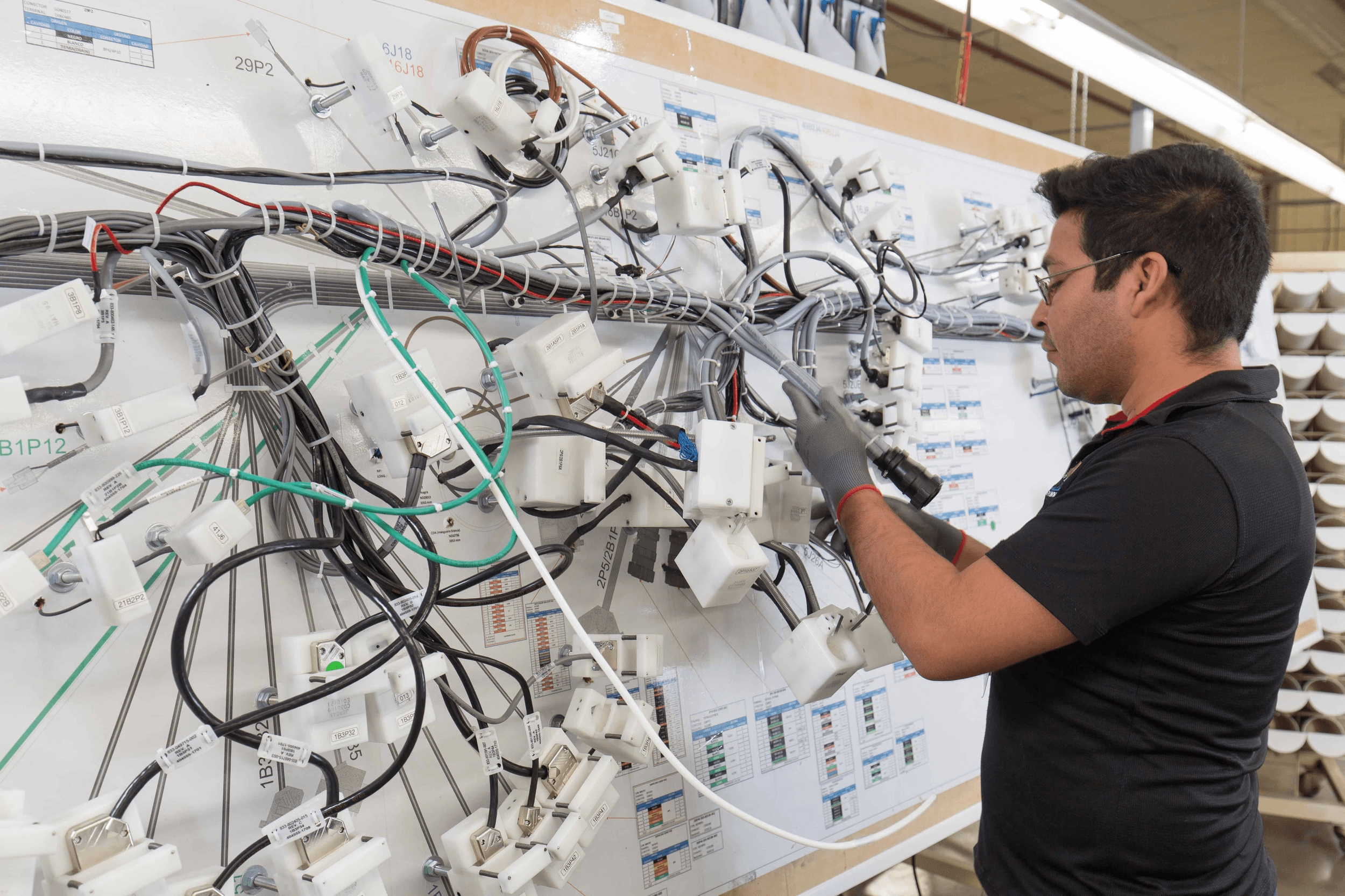 Technician assembling a complex wire harness